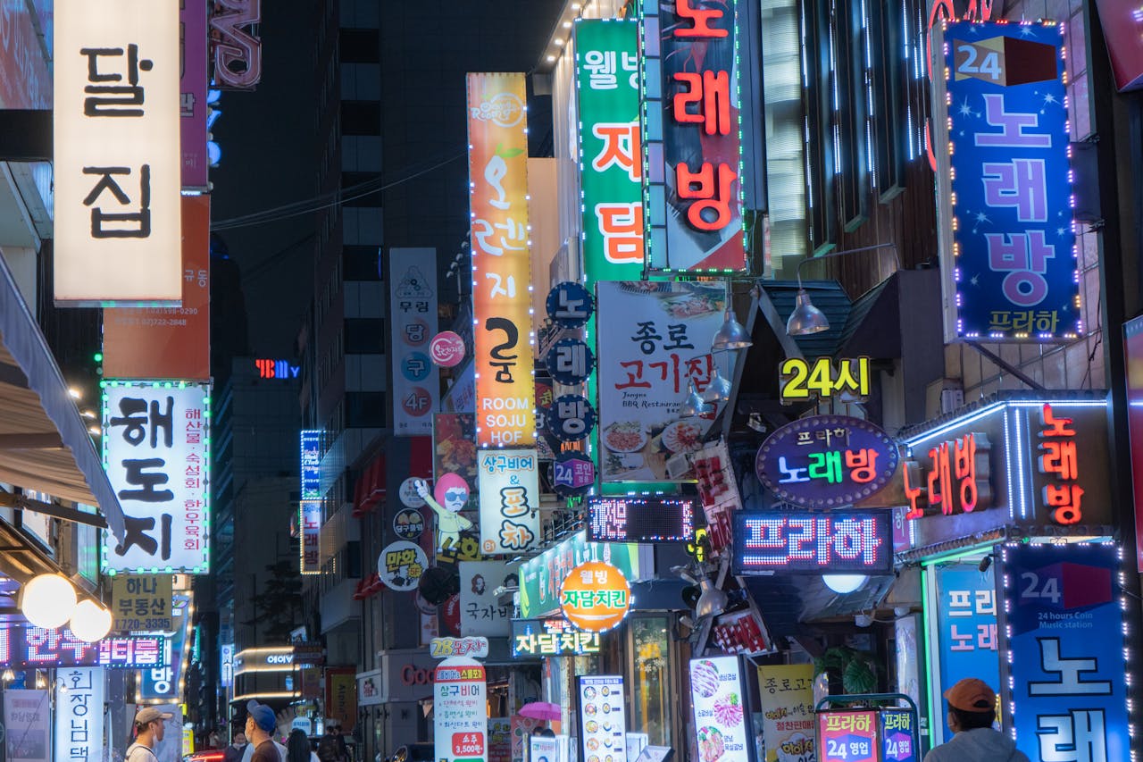 Explore the bustling night scene of Myeongdong with neon signs and vibrant city lights in Seoul, South Korea.