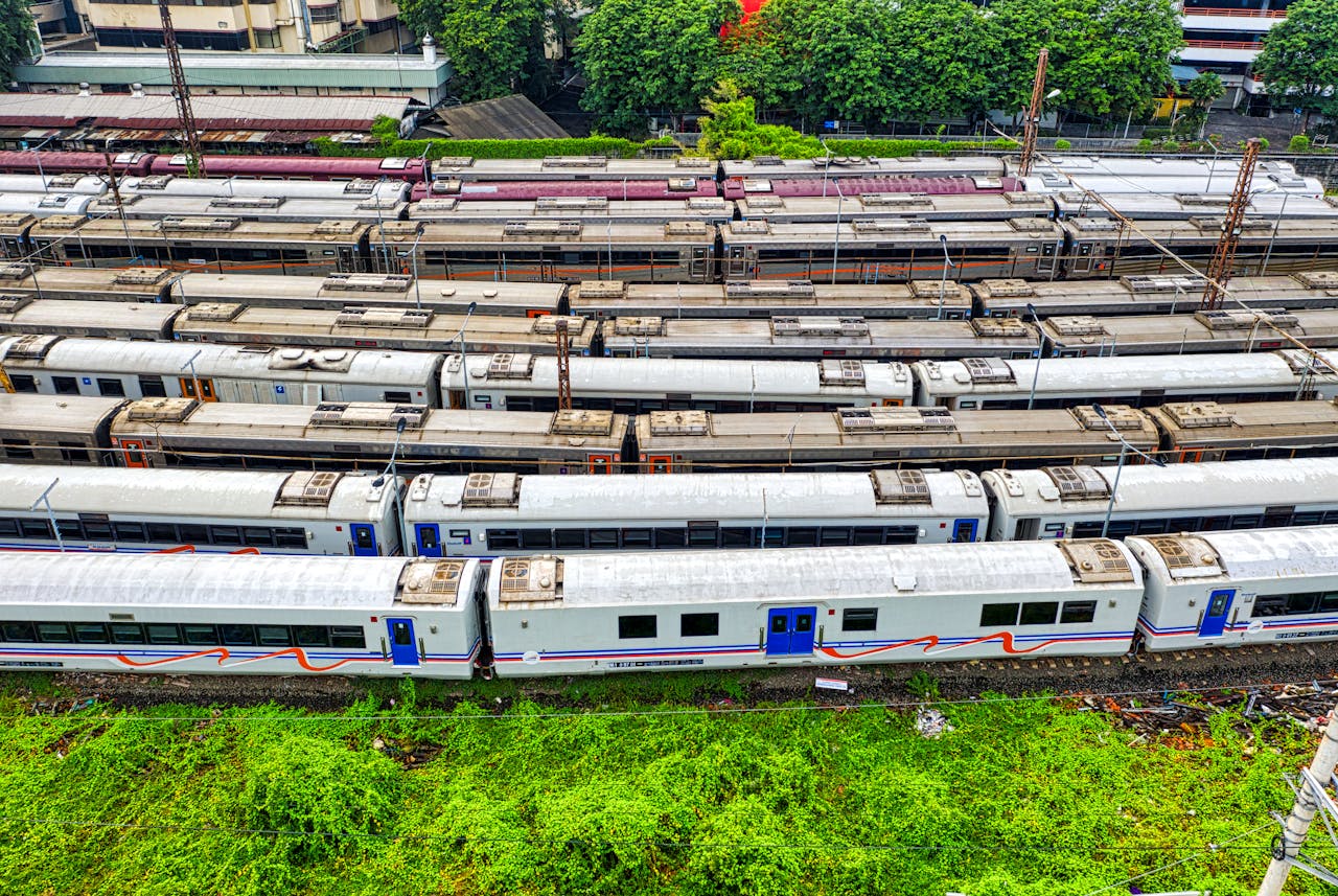 High angle view of trains parked in a green rail yard in Jakarta, Indonesia, showcasing urban transportation.